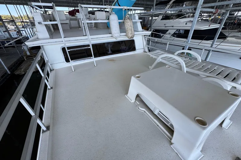 Slide: The Image of 1993 Gibson 44 Cabin Yacht deck with seating and railings in a marina. - 54