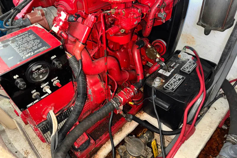 Slide: The Image of Engine compartment of a 1993 Gibson 44 Cabin Yacht with red components and battery. - 48
