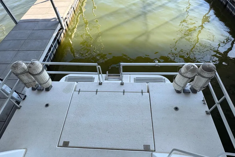 Slide: The Image of 1993 Gibson 44 Cabin Yacht stern view at dock with fenders. - 55