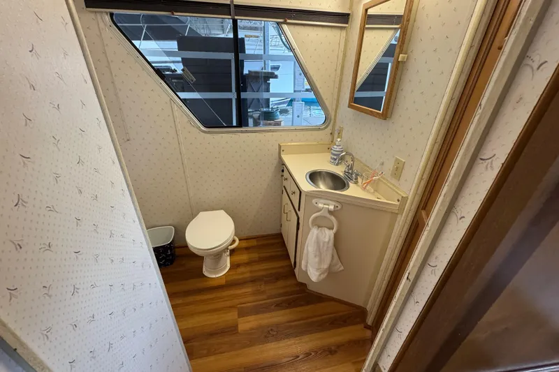 Slide: The Image of Bathroom interior of 1993 Gibson 44 Cabin Yacht with toilet, sink, and wood flooring. - 26