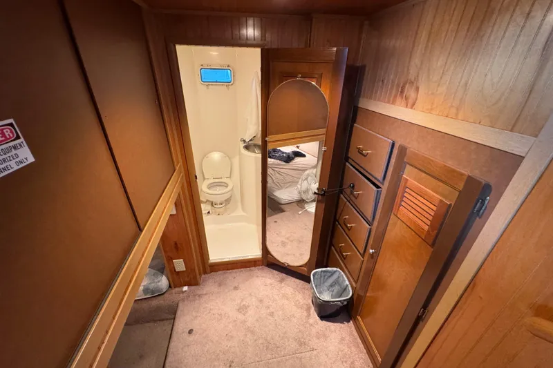 Slide: The Image of 1993 Gibson 44 Cabin Yacht interior with bathroom, wooden cabinetry, and mirror. - 37