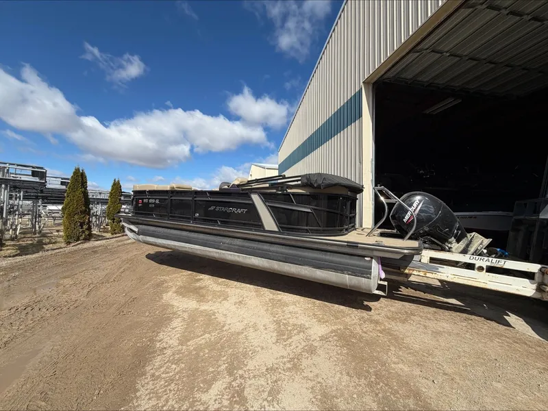 Slide: The Image of 2023 Starcraft SLS 3 pontoon boat outside warehouse. - 11