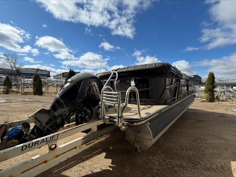 Slide: The Image of 2023 Starcraft SLS 3 pontoon boat on trailer, sunny day. - 2