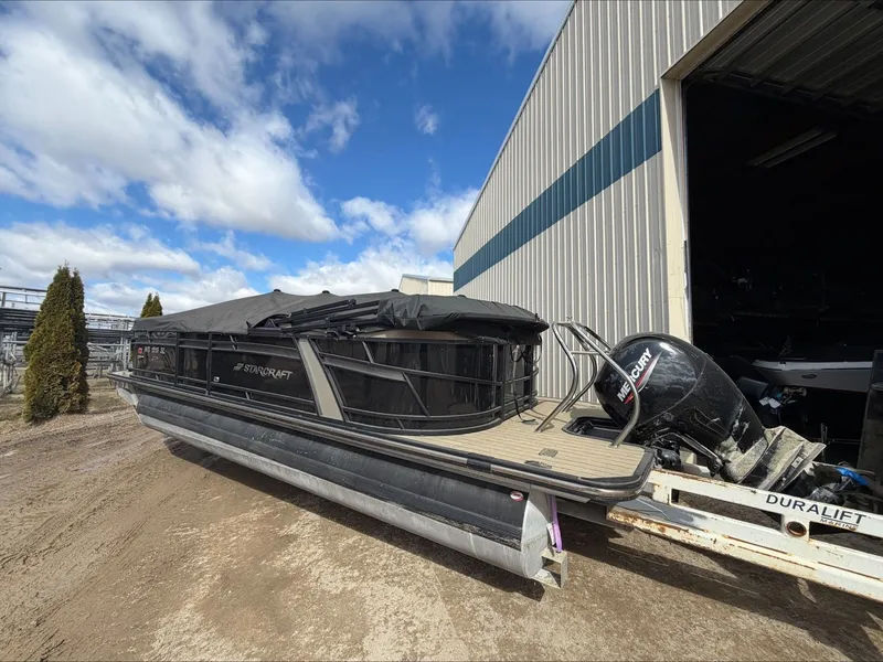 Slide: The Image of 2023 Starcraft SLS 3 pontoon boat with Mercury engine, parked outside. - 8