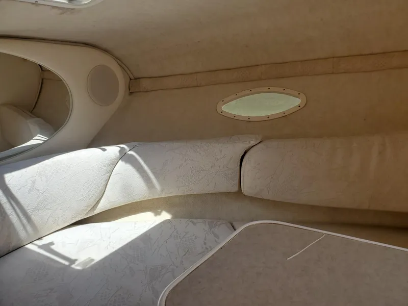 Slide: The Image of Interior cabin of a 2001 Sea Ray 245 Weekender boat, featuring beige upholstery. - 10
