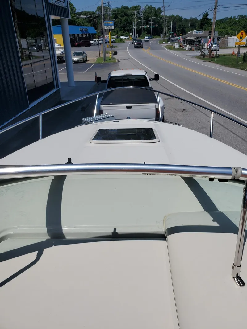 Slide: The Image of 2001 Sea Ray 245 Weekender boat on trailer, parked on roadside near dealership. - 16