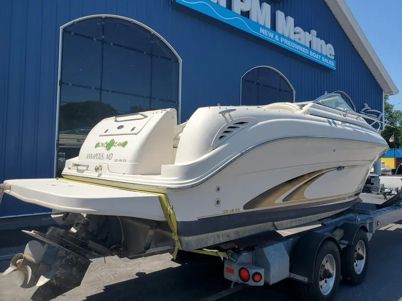 Slide: The Image of 2001 Sea Ray 245 Weekender boat on trailer outside marine dealership. - 3