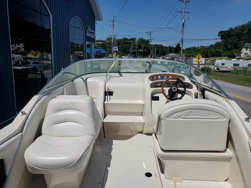 Slide: The Image of 2001 Sea Ray 245 Weekender boat interior with white seating and steering wheel. - 5