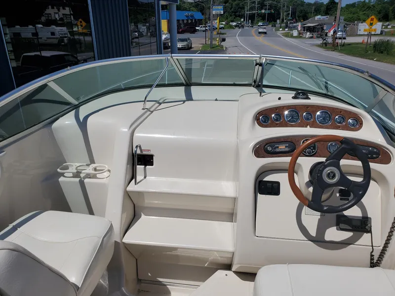 Slide: The Image of 2001 Sea Ray 245 Weekender boat cockpit with steering wheel and dashboard controls. - 7