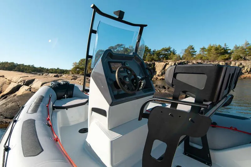 Slide: The Image of Manufacturer Provided Image: Zodiac Open 5.5 boat 2026 on calm water with rocky background. - 2