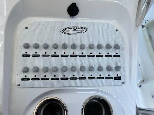 Slide: The Image of Control panel of a 2008 Spectre 34 boat with multiple switches and cup holders. - 24