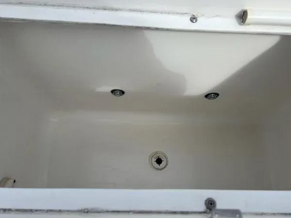Slide: The Image of Empty storage compartment in a 2008 Spectre 34 boat, featuring drainage holes. - 30