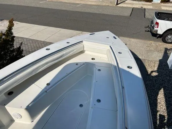 Slide: The Image of 2008 Spectre 34 boat bow with seating, parked near a road. - 43