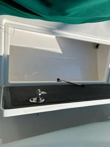 Slide: The Image of Open storage compartment on a 2008 Spectre 34 boat with green cover. - 45