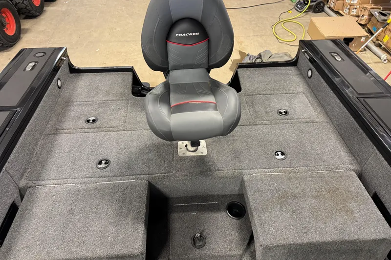 Slide: The Image of 2024 Tracker Targa V-18 Combo boat interior with gray seating and carpeted flooring. - 12