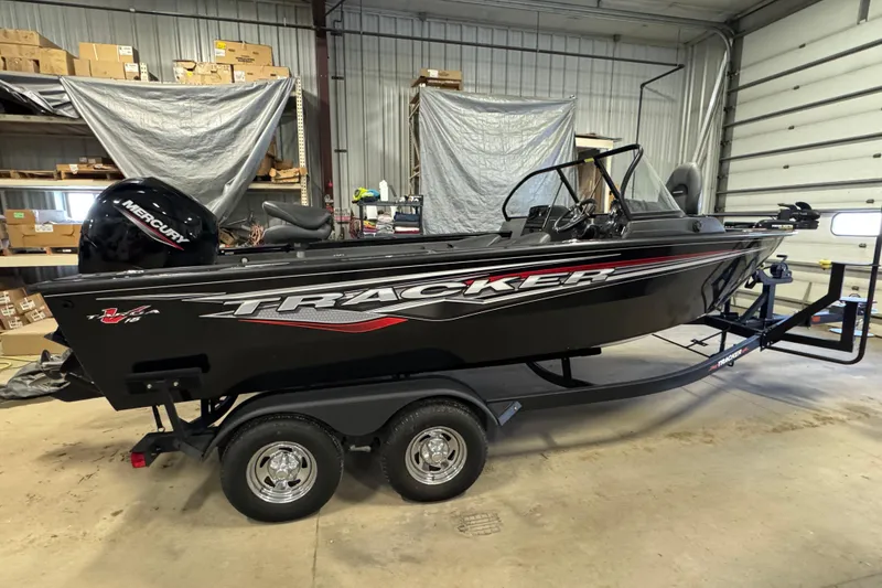 Slide: The Image of 2024 Tracker Targa V-18 Combo boat in a garage, featuring a Mercury engine. - 3