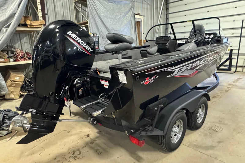 Slide: The Image of 2024 Tracker Targa V-18 Combo boat with Mercury engine in a garage setting. - 4