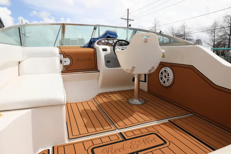 Slide: The Image of 1998 Searay Sundancer boat interior with white seating and wood-style flooring. - 8