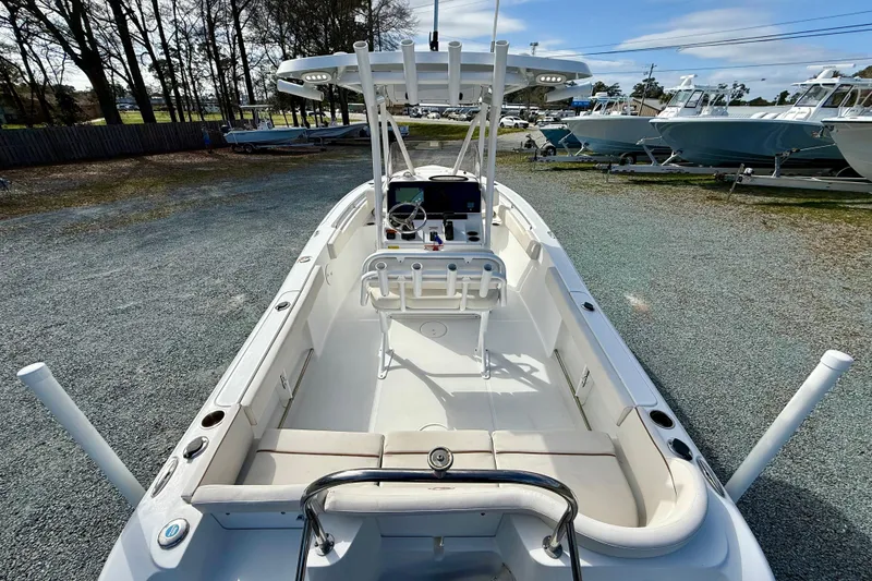Slide: The Image of 2022 Sea Hunt Ultra 229 boat with center console and seating, parked on gravel lot. - 14