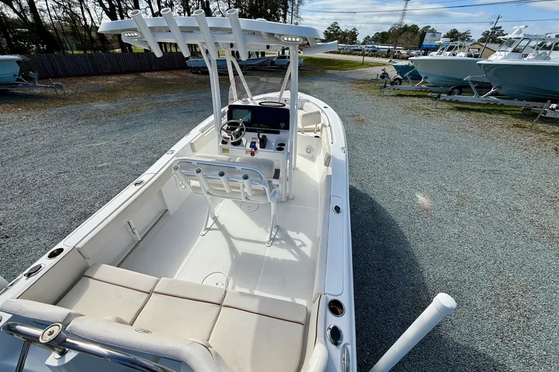 Slide: The Image of 2022 Sea Hunt Ultra 229 boat with seating and outboard motor in a marina. - 15