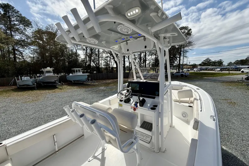 Slide: The Image of 2022 Sea Hunt Ultra 229 boat with center console and rod holders, parked outdoors. - 18