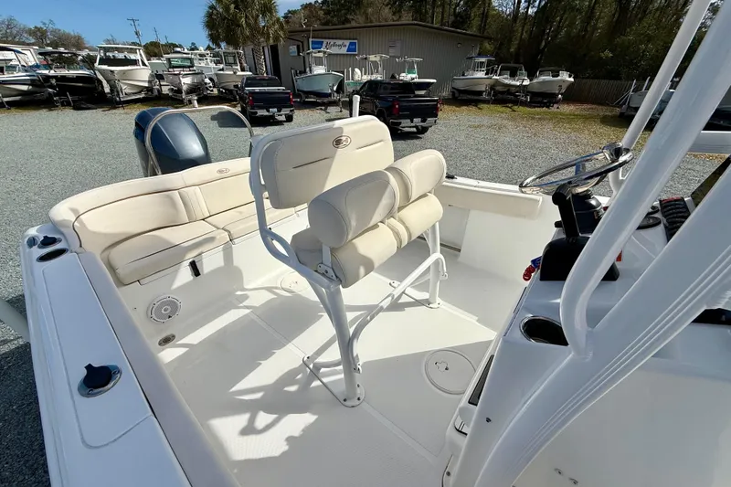 Slide: The Image of 2022 Sea Hunt Ultra 229 boat interior with covered seats and engine, parked outdoors. - 22