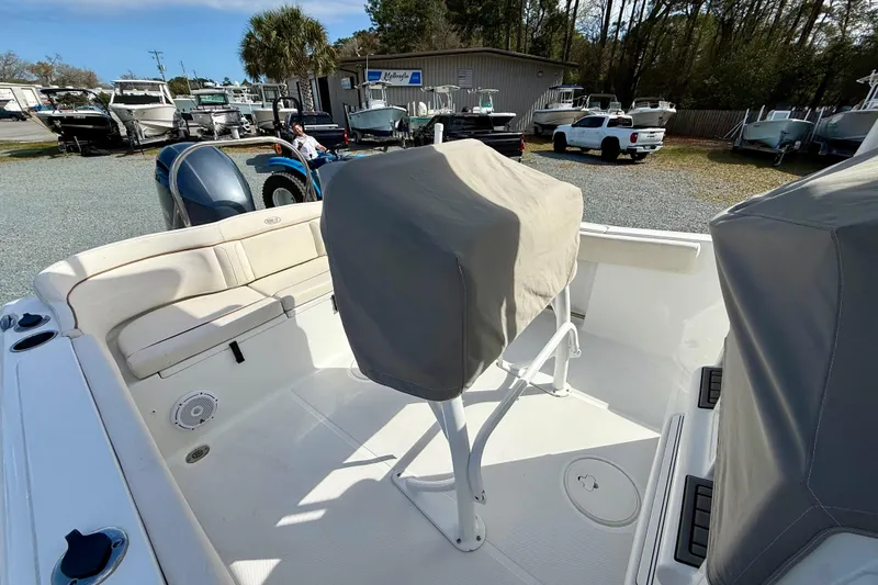 Slide: The Image of 2022 Sea Hunt Ultra 229 boat T-top with speakers and rod holders against blue sky. - 23