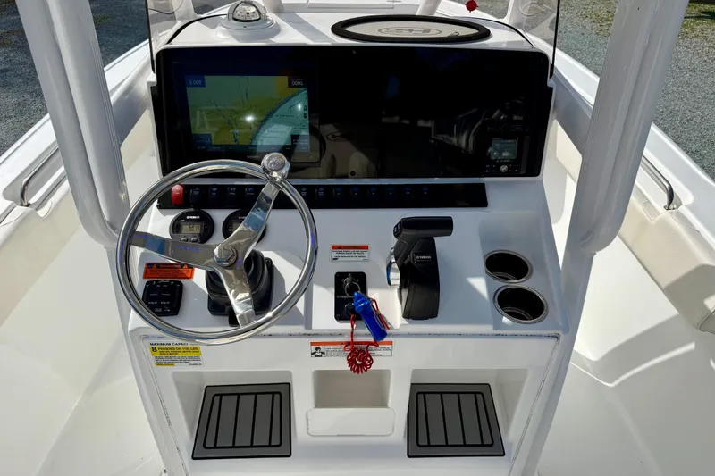 Slide: The Image of 2022 Sea Hunt Ultra 229 boat with covered console, parked outdoors. - 25