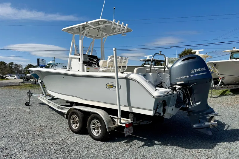 Slide: The Image of 2022 Sea Hunt Ultra 229 boat with Yamaha 200 outboard motor, parked on gravel. - 3
