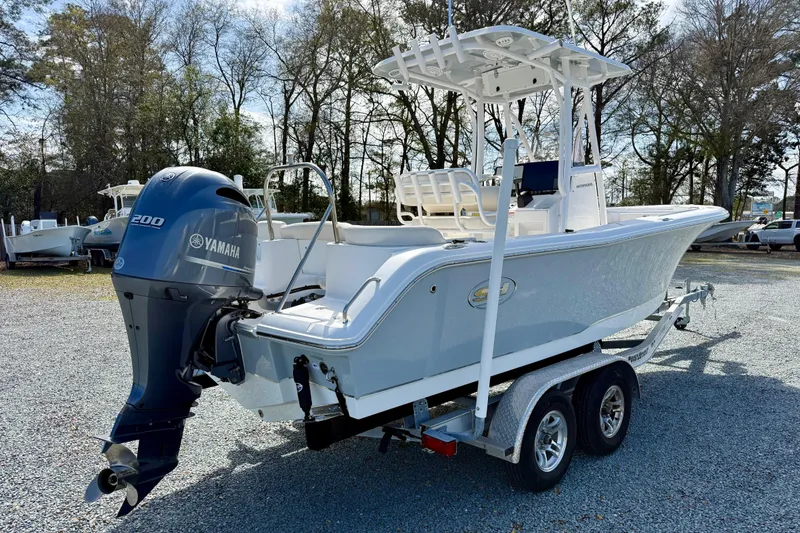 Slide: The Image of 2022 Sea Hunt Ultra 229 boat on trailer, displayed outdoors under clear blue sky. - 7