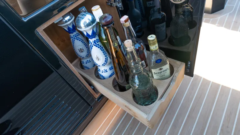 Slide: The Image of Beverage storage on 2022 Pardo Yachts 50, featuring assorted bottles in a wooden rack. - 35
