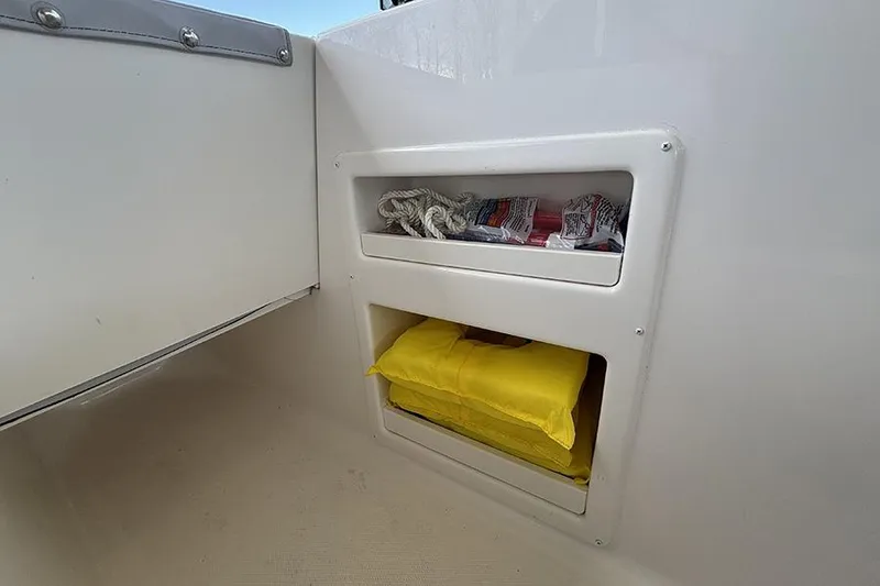Slide: The Image of Storage compartment on 2024 Bayliner Element M17 boat with rope and safety gear. - 19