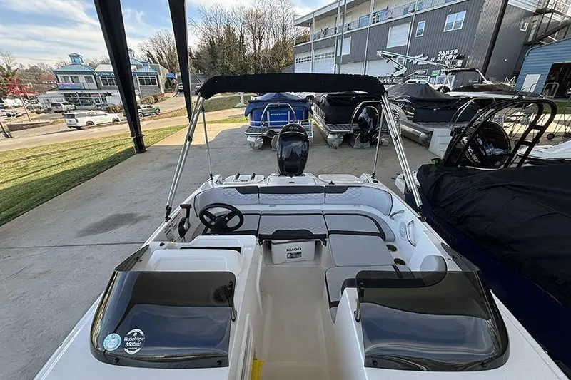 Slide: The Image of 2024 Bayliner Element M17 boat interior with steering wheel and seating, docked outdoors. - 20