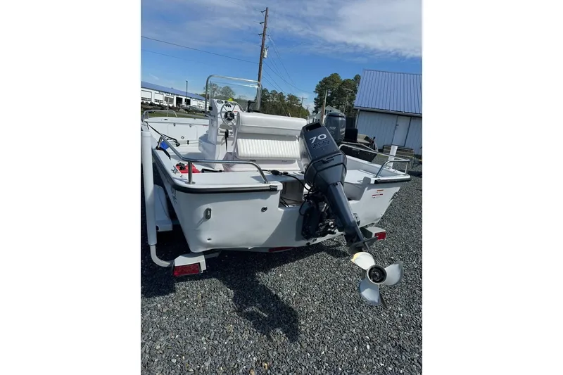 Slide: The Image of 2009 Triumph 1700 Skiff boat with outboard motor on gravel lot. - 1