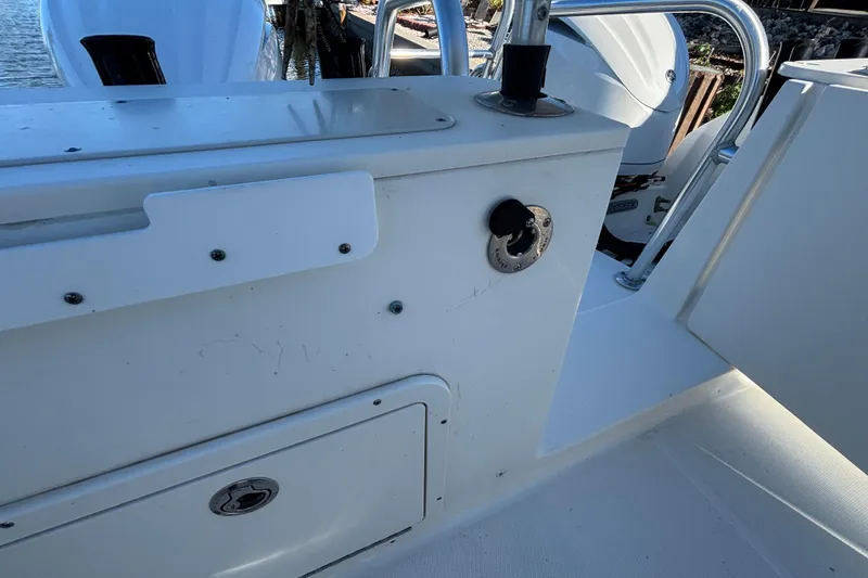 Slide: The Image of 2023 World Cat 295 CC boat interior with storage compartment and railing. - 12