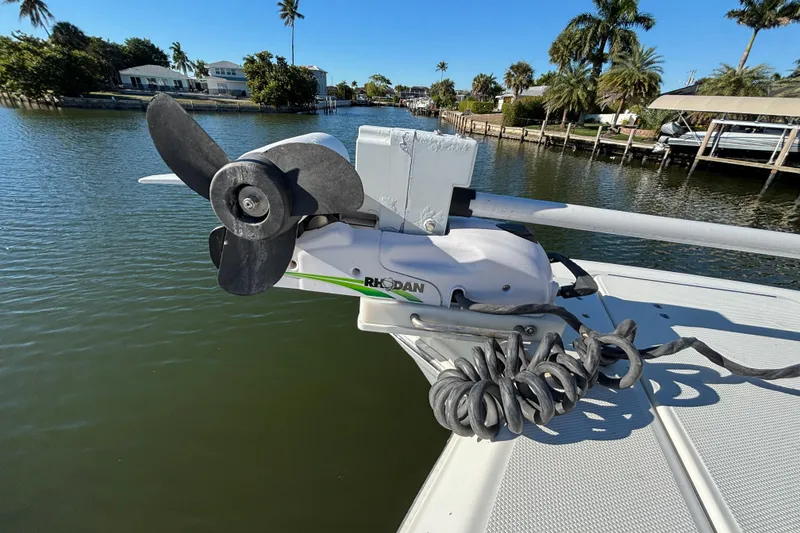 Slide: The Image of 2023 World Cat 295 CC boat with Rhodan trolling motor on a sunny waterfront. - 17