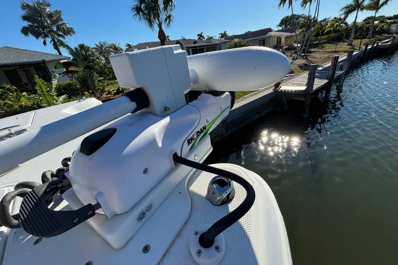 Slide: The Image of 2023 World Cat 295 CC boat with trolling motor docked by waterfront homes. - 18