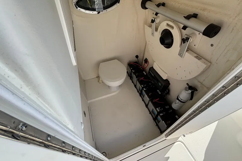 Slide: The Image of 2023 World Cat 295 CC boat interior with toilet, batteries, and fire extinguisher. - 19