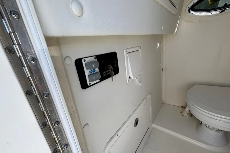 Slide: The Image of Interior of 2023 World Cat 295 CC boat featuring a compact marine toilet. - 22