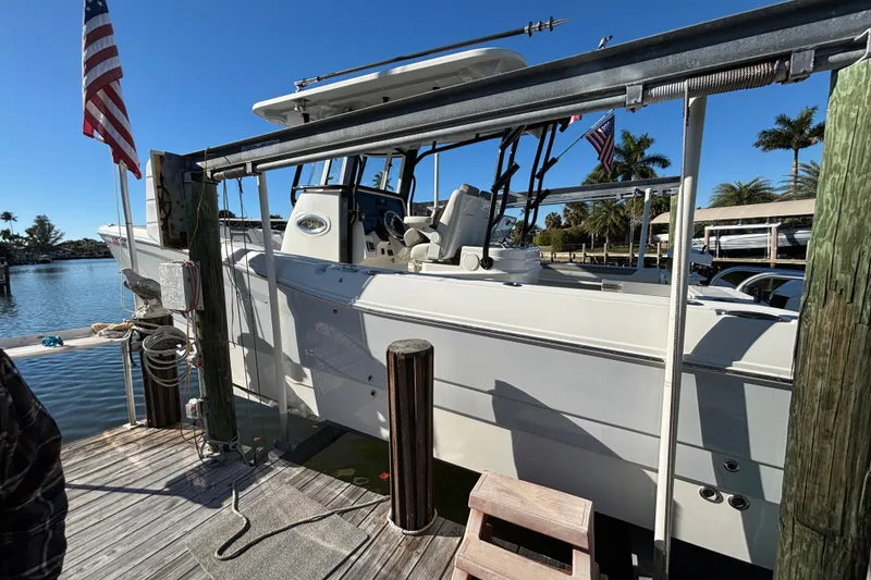 Slide: The Image of 2023 World Cat 295 CC boat docked with American flag, sunny day. - 3