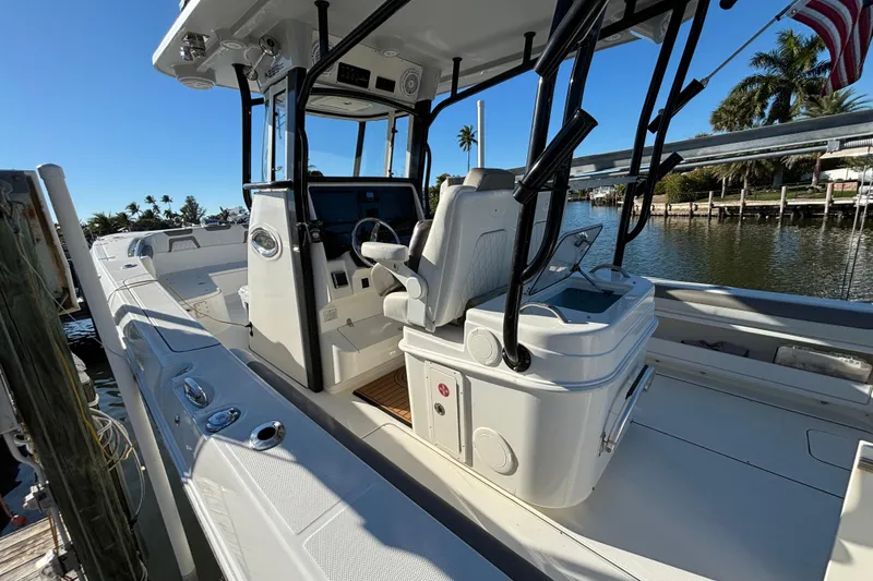 Slide: The Image of 2023 World Cat 295 CC boat interior with helm, seating, and water view. - 4