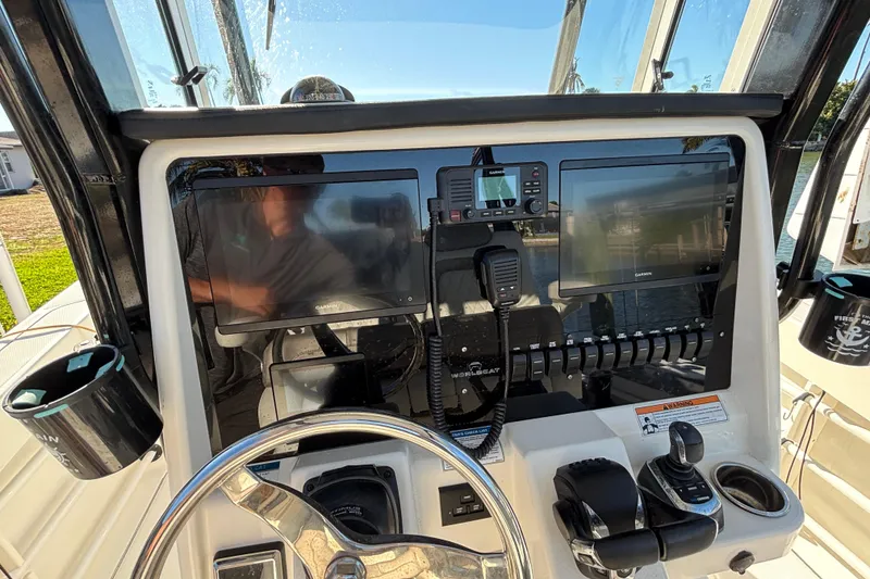Slide: The Image of 2023 World Cat 295 CC boat dashboard with Garmin displays and controls. - 6
