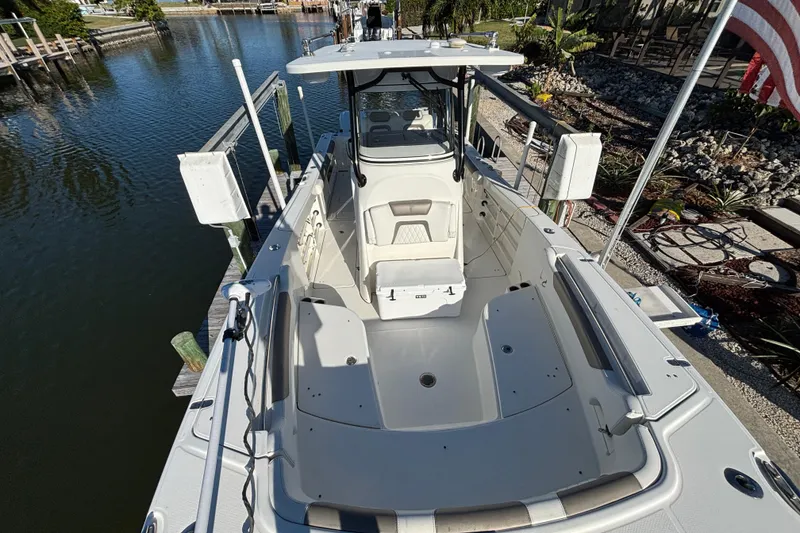 Slide: The Image of 2023 World Cat 295 CC boat docked, showcasing spacious deck and seating area. - 9