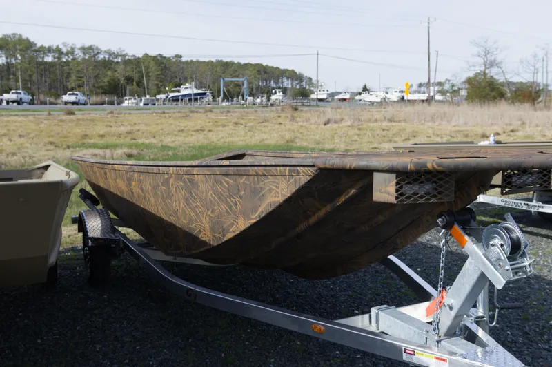 Slide: The Image of 2026 G3 Gator Tough 17 DK boat on trailer, camo design, parked outdoors. - 9