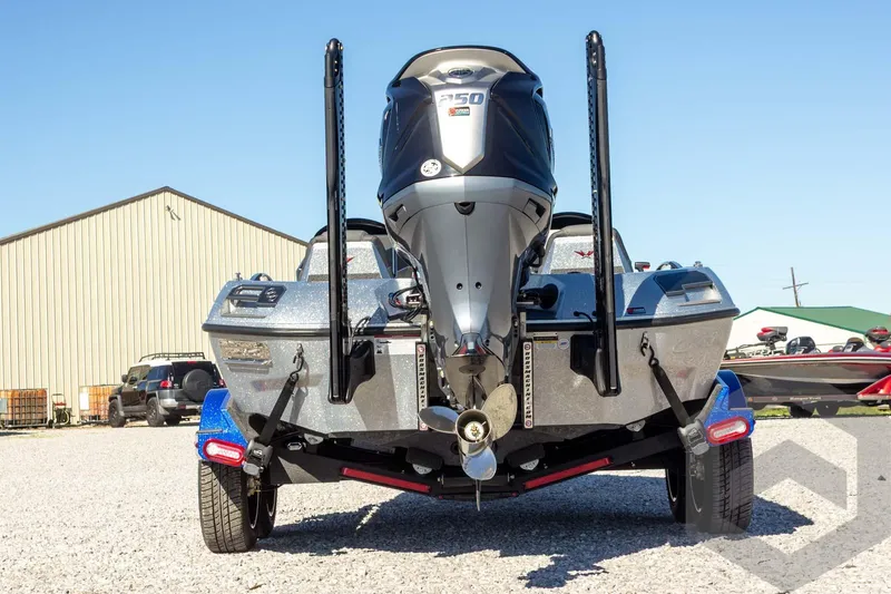 Slide: The Image of 2026 Vexus VXs21 boat with powerful outboard motor, parked on gravel near a building. - 10