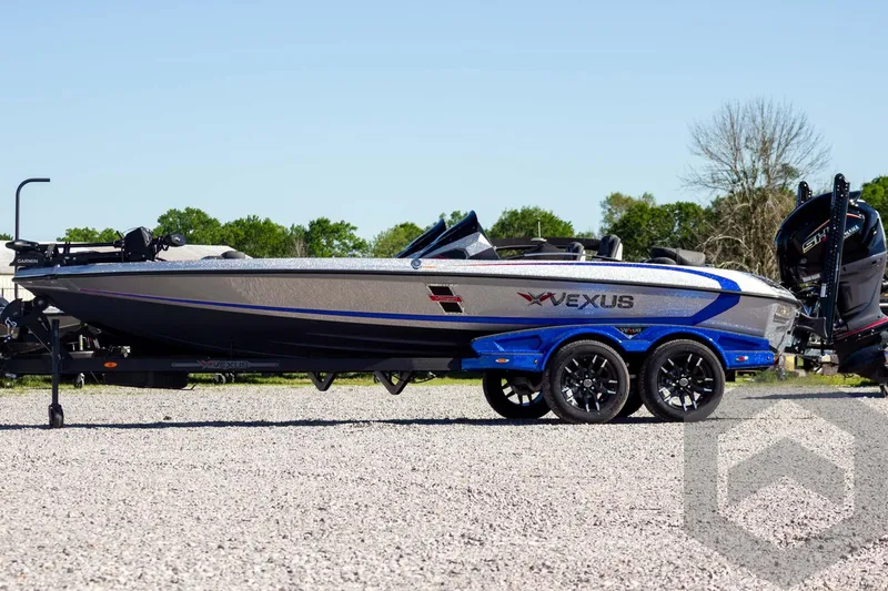 Slide: The Image of 2026 Vexus VXs21 boat on trailer, sleek design, blue accents, parked outdoors. - 5