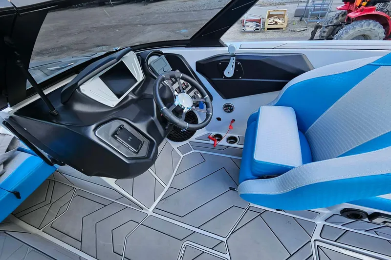 Slide: The Image of Interior of a 2022 Supreme S220 boat featuring a modern dashboard and blue seating. - 20