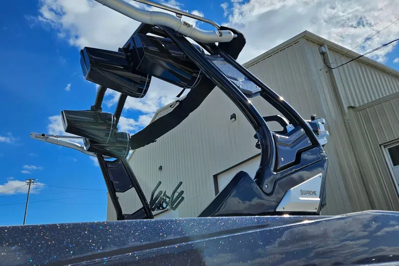 Slide: The Image of 2022 Supreme S220 boat tower against blue sky and building background. - 4