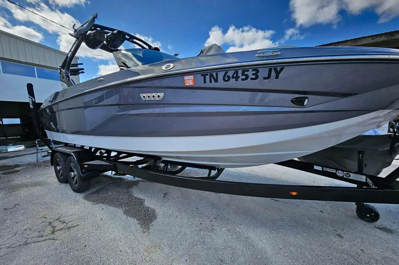 Slide: The Image of 2022 Supreme S220 boat on trailer, gray exterior, parked outdoors under blue sky. - 5