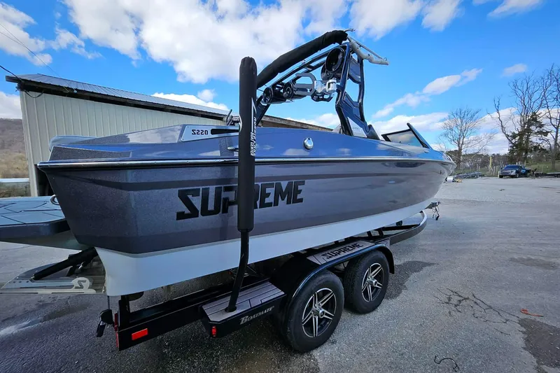 Slide: The Image of 2022 Supreme S220 boat on trailer, sleek design under blue sky. - 6